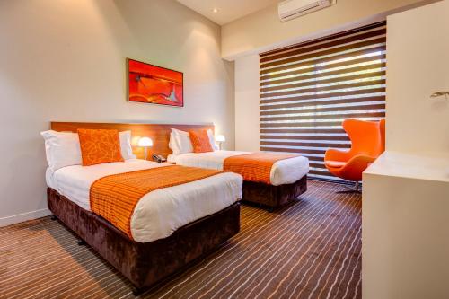 A bed or beds in a room at Mantra Charles Hotel