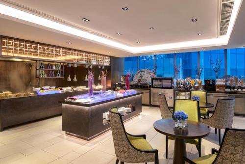 a restaurant with a bar and tables and chairs at Somerset Swan Lake Hefei in Hefei