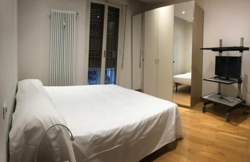 a bedroom with a white bed and a television at Suite i Gessi in San Ruffillo