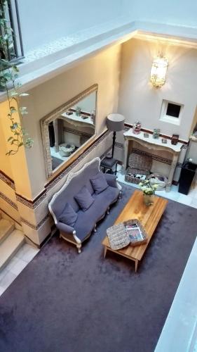 a living room with a couch and a table and a mirror at Le Petit París in Seville