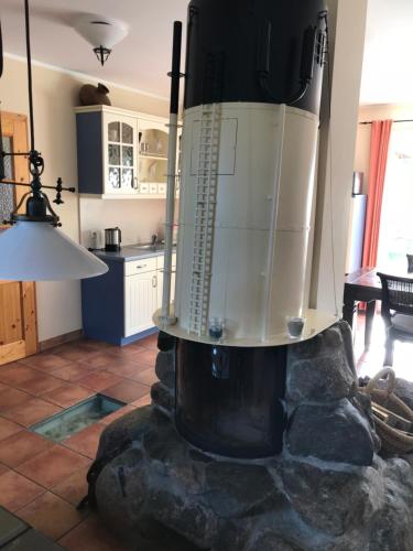 a kitchen with a large stone fireplace in a living room at "Leuchtturmhaus" by Ferienhaus Strandgut in Born
