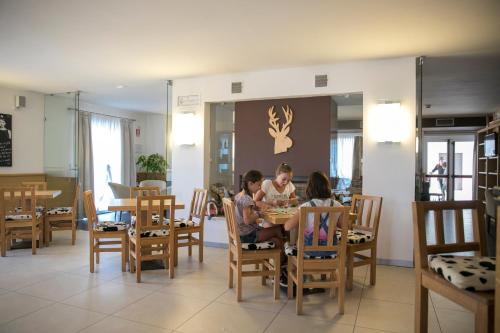 a group of people sitting at a table in a restaurant at Hotel Luna Bianca Folgaria in Folgaria