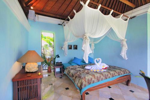 a bedroom with a bed with a swan on it at The Mahogany Villa Ubud in Tegalalang
