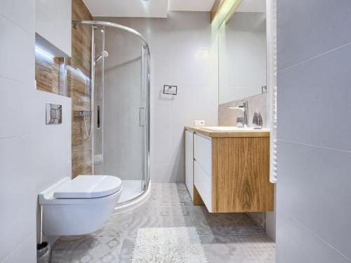 a bathroom with a toilet and a sink and a shower at VisitZakopane - Dolomite SPA Apartment in Zakopane