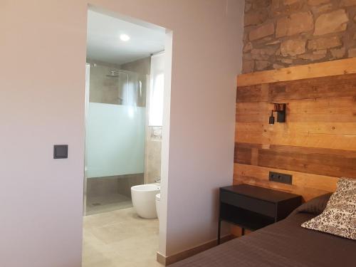 um quarto com uma cama e uma casa de banho com um chuveiro em Les Muntades em Jorba