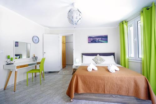 ハニア・タウンにあるNea Chora Maisonetteのベッドルーム1室(ベッド1台、デスク、緑のカーテン付)