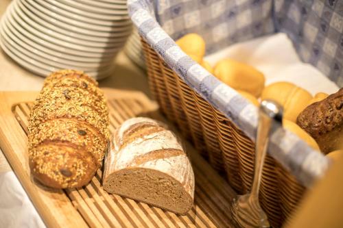 a tray with breads and loaves of bread at Hotel Luna Bianca Folgaria in Folgaria