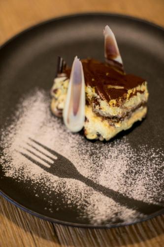 a piece of cake on a plate with a fork at Hotel Luna Bianca Folgaria in Folgaria