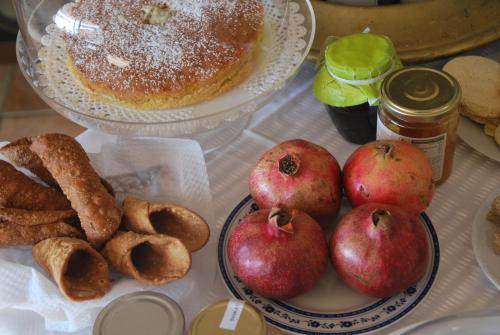 a table with a plate of apples and pretzels and bread at Casa tipica siciliana patronale home BedandBreakfast TreMetriSoprailCielo Camere con vista, colazione interna in terrazzo panoramico in Caltagirone