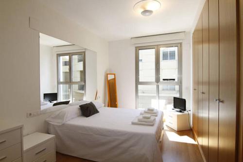 バレンシアにあるAPARTAMENT-PRIMERA LINEA PLAYA PATACONAの白いベッドルーム(大型ベッド1台、窓付)