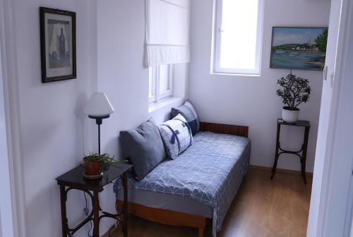 a small room with a bed and two windows at Sára Vendégház in Szentes