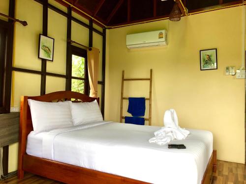 a bedroom with a white bed and a window at Baan Thung Home Stay in Prasat
