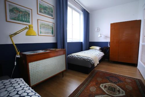a room with two beds and a lamp and a window at Sára Vendégház in Szentes