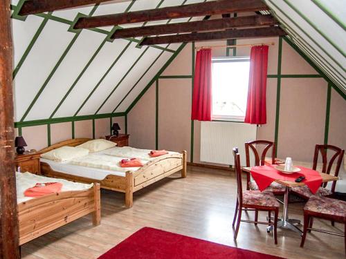 una camera da letto con due letti, un tavolo e delle sedie di Pension Haus Saarland a Oberhof