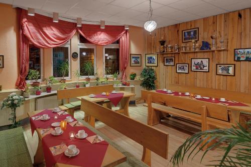 a restaurant with benches and tables in a room at Pension Haus Saarland in Oberhof