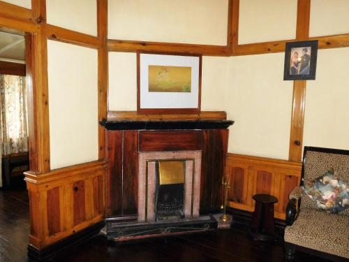 a living room with a fireplace and a picture on the wall at The Heritage Club - Tripura Castle Hotel and Spa in Shillong