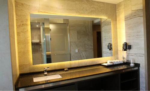 a bathroom with a sink and a large mirror at Hotel Dongbang in Jinju