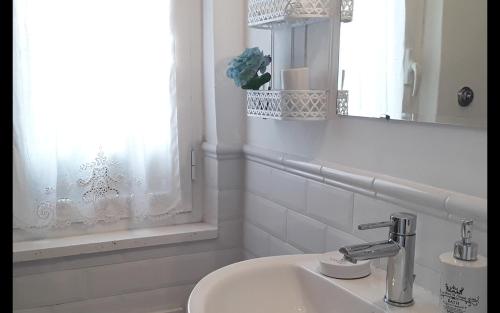 ein Badezimmer mit Waschbecken, Spiegel und Fenster in der Unterkunft L'Attico di San Saba in Rom