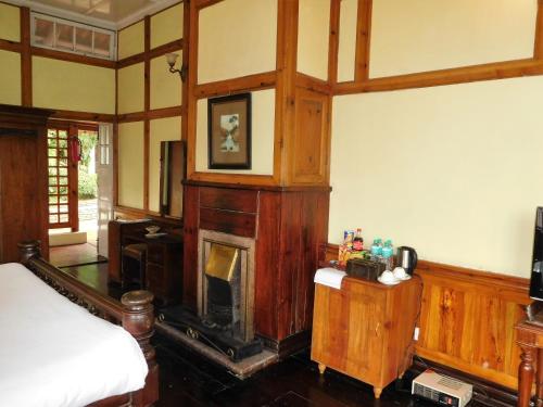 a room with a fireplace and a bed in it at The Heritage Club - Tripura Castle Hotel and Spa in Shillong