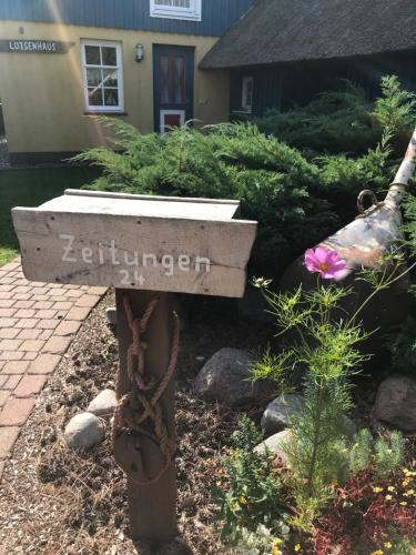 a garden with a sign that says euthanasia at "Leuchtturmhaus" by Ferienhaus Strandgut in Born