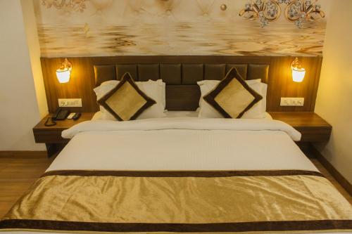 a bedroom with a large bed with two pillows at Solitaire Hotel And Resorts in Ujjain