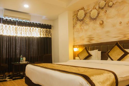 a hotel room with two beds and a table at Solitaire Hotel And Resorts in Ujjain