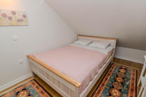 a small bedroom with a bed in a room at Ovidijus Apartment in Pervalka