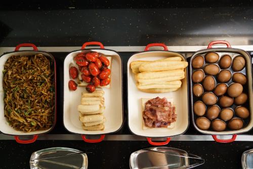 four trays filled with different types of food at Cendre Hotel (Lingering Garden and Tiger Hill) in Suzhou