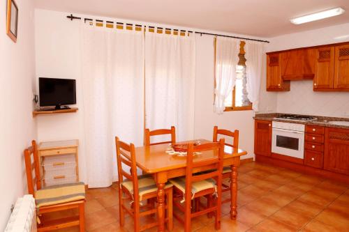 a kitchen and dining room with a wooden table and chairs at Casa Enpiera II - Turistrat in Cinctorres