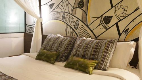 a white couch with three pillows on top of it at Bamboori Boutique Resort in Chiang Mai
