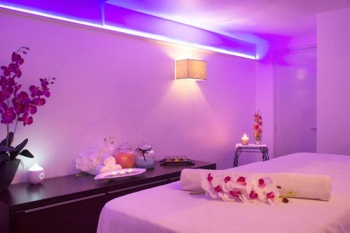 a purple room with two beds with pink lighting at The Originals Boutique, Hôtel du Pont Roupt, Mende in Mende