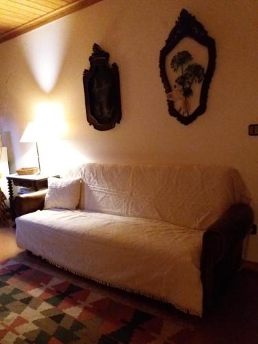a living room with a white couch and a mirror at A casa da serra - alojamento local in Casal Velho