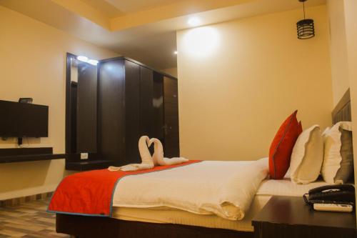a hotel room with a bed with towels on it at Solitaire Hotel And Resorts in Ujjain