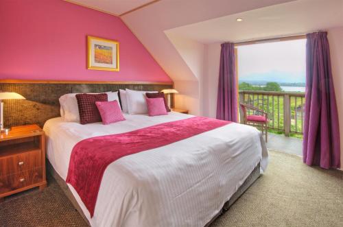 Tempat tidur dalam kamar di Loch Lomond Waterfront Luxury Lodges