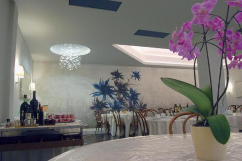 a dining room with a table with purple flowers on it at Hotel Brasile in Montecatini Terme