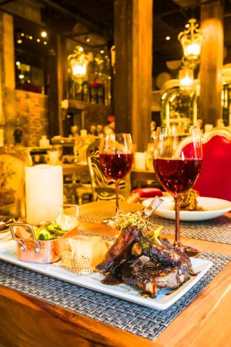 a table with a plate of food and two glasses of wine at ONOMO Hotel Waterfront in Cape Town