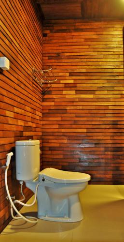 a bathroom with a toilet and a brick wall at Ocean Terrace Suite And Spa Luxury in Nusa Penida