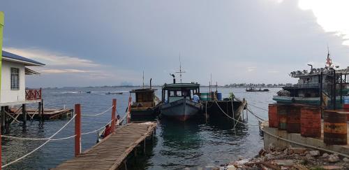 two boats docked at a dock in the water at The Wharf in Semporna