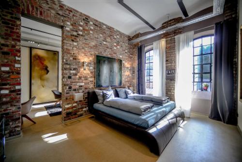 a living room with a couch and a brick wall at Carl-Kaiser-Loft I in Solingen