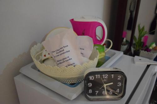 a clock sitting on a shelf next to a basket at Sigiri Saman Home Stay in Sigiriya