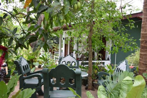 a patio with chairs and a table in a garden at Sigiri Saman Home Stay in Sigiriya