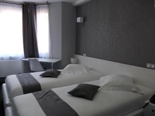 a bedroom with two beds and a window at Hotel Phenix in Brussels