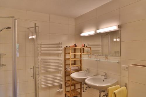 ein Bad mit 2 Waschbecken und einer Dusche in der Unterkunft Haus Burbach in Zellberg