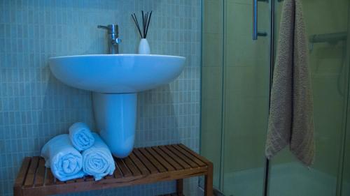 La salle de bains est pourvue d'un lavabo, d'une douche et de serviettes. dans l'établissement Apartamento en la Magalona, à Icod de los Vinos
