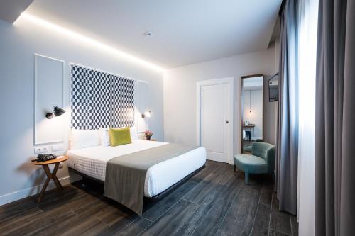 a hotel room with a bed and a chair at Intelier Victoria in San Sebastián