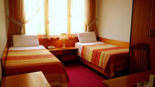 a hotel room with two beds and a window at Kruja Hotel in Tirana
