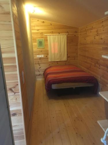 TressignauxにあるÉcologîteのログキャビン内のベッド1台が備わる小さな客室です。