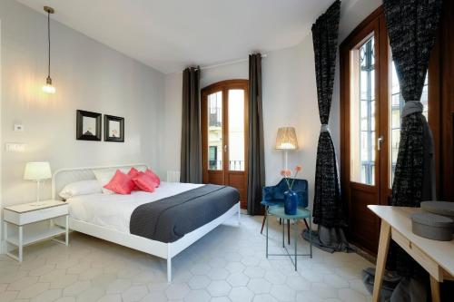 een slaapkamer met een bed met rode kussens erop bij tuGuest San Gil Apartments in Granada