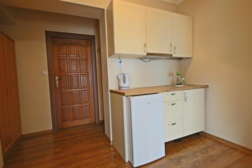 a kitchen with a white refrigerator and a door at Na Wierchu in Bukowina Tatrzańska