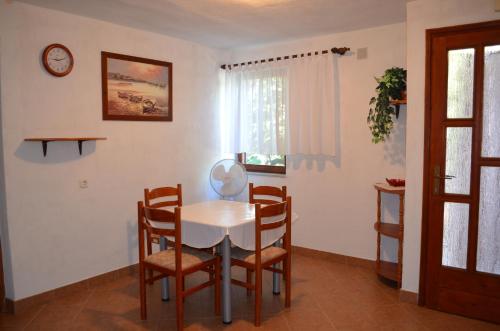 a dining room with a white table and chairs at Holiday Home Garina in Draga Bašćanska